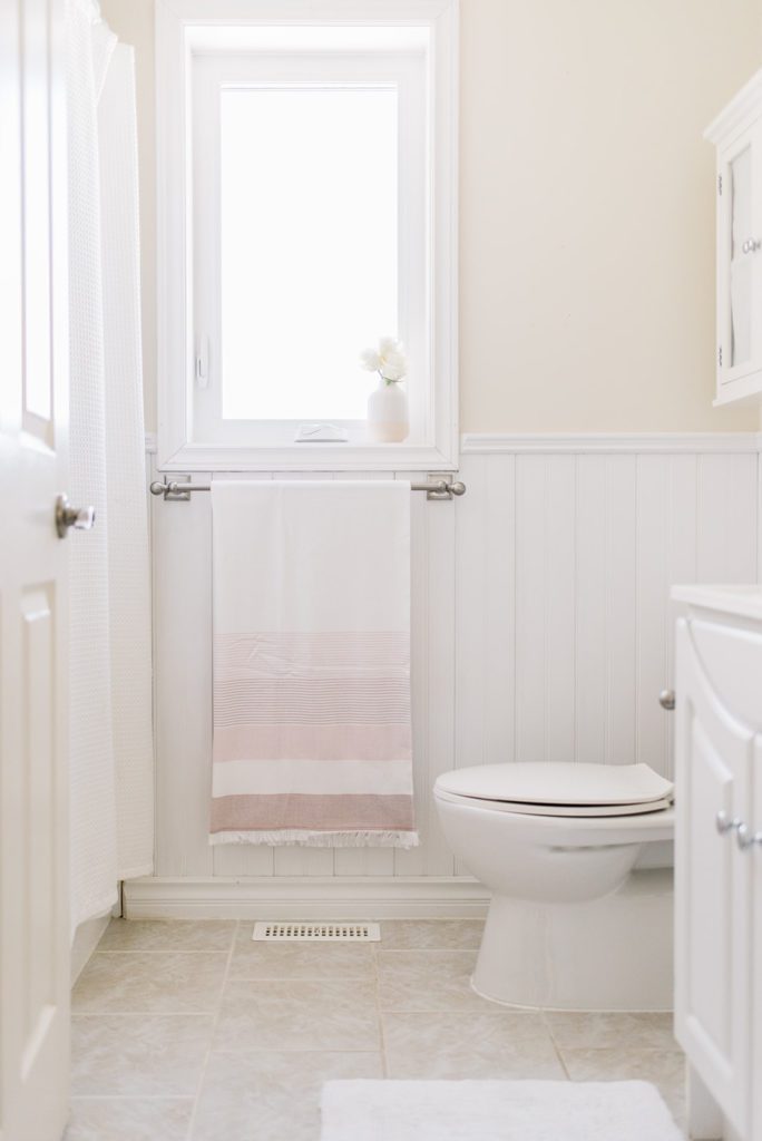 A neutral bathroom with a pink turkish towel