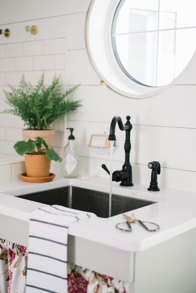 Watering houseplants in a farmhouse sink