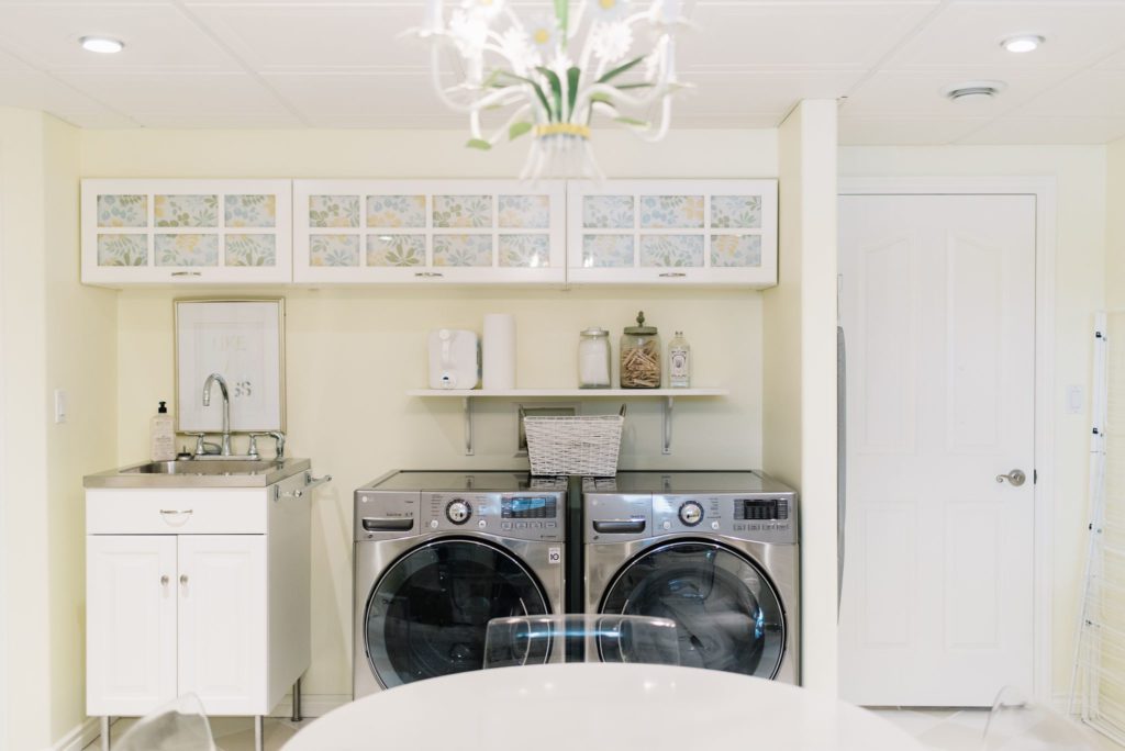 laundry room with built in storage cabinets and yellow walls