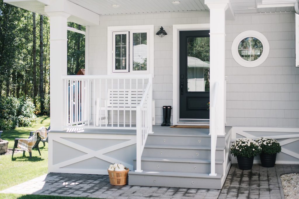 Front porch with grey decking and white railing 