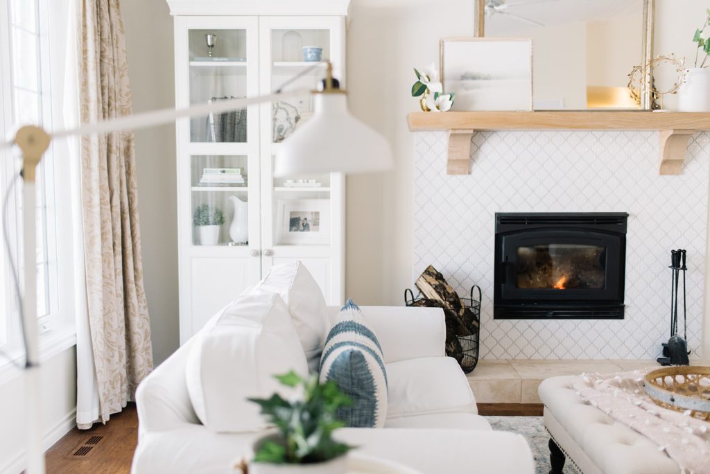 A living room with white couches and a fireplace