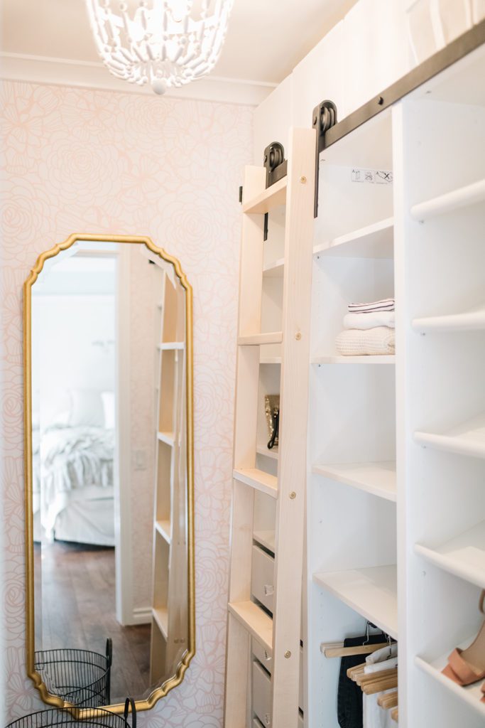 large mirror and rolling ladder in walk in closet