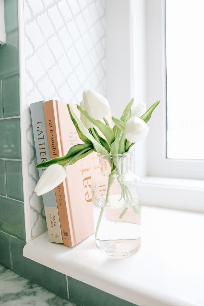 A vase filled with tulips and cook books