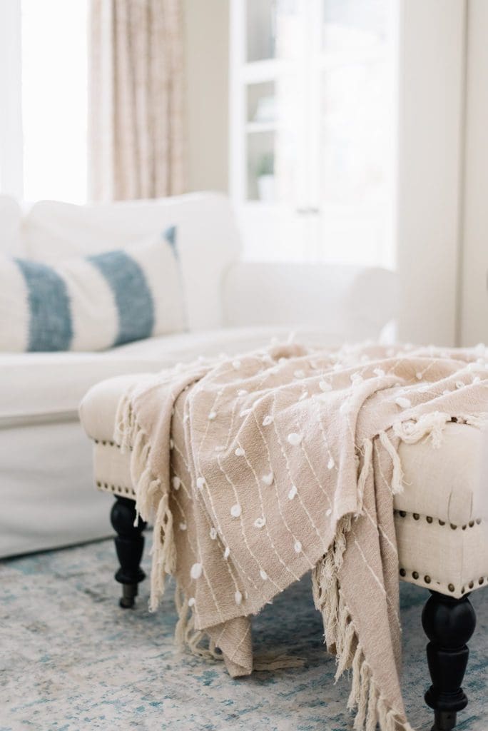 a pink throw draped over an ottoman