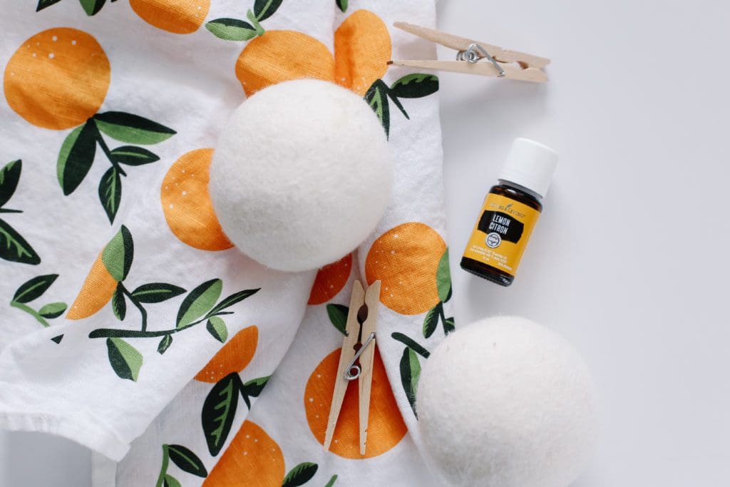 Woolen dryer balls and a bottle of Lemon essential oil