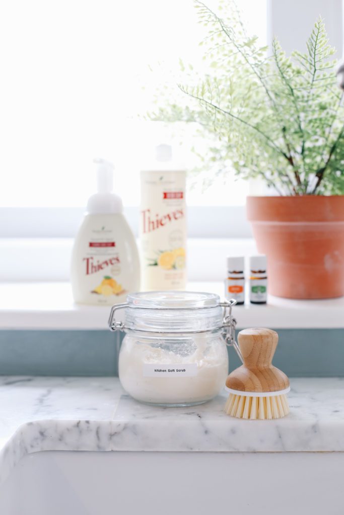 A jar of natural cleaner sitting on a counter beside a scrub brush