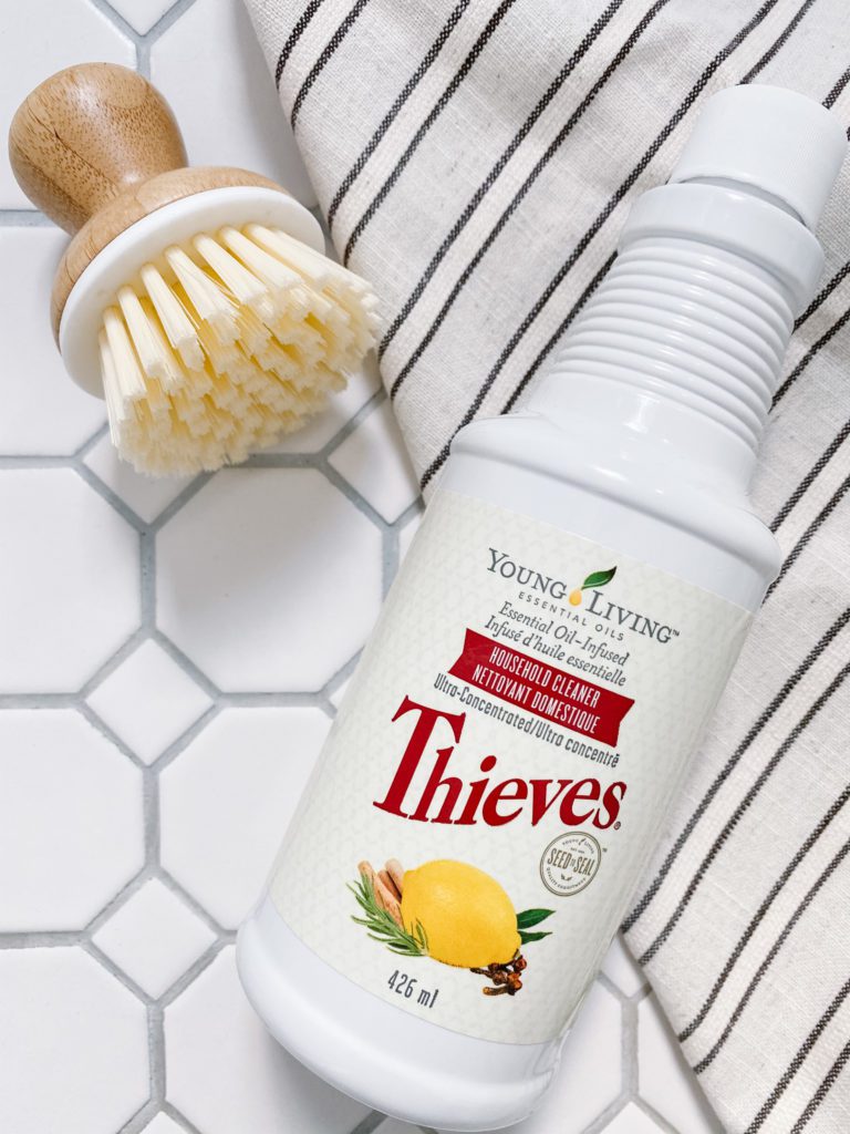 A bottle of Thieves cleaner and a bamboo scrub brush