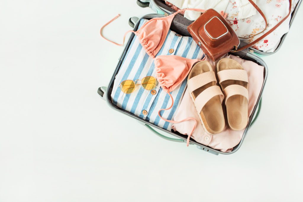 suitcase full of summer travel accessories