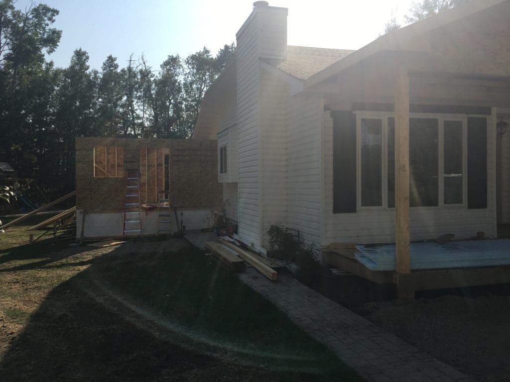 A house under construction with trees in the background