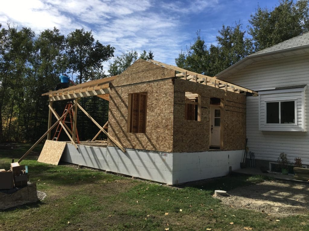 an extension being built on the side of a small house