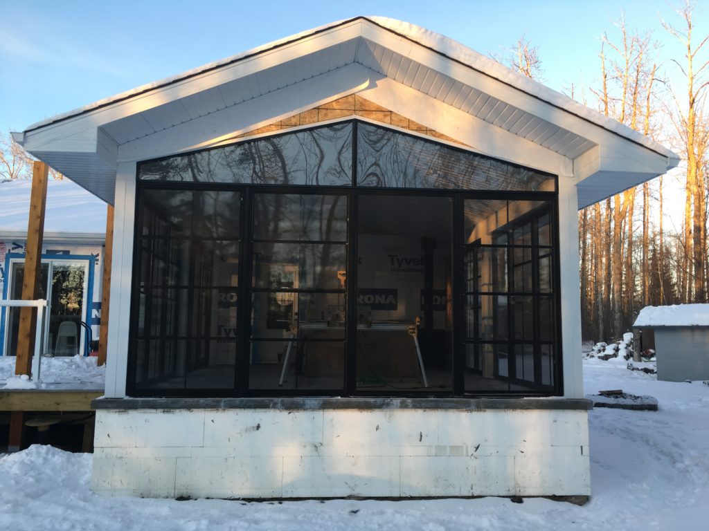 partially finished sun room addition covered in snow