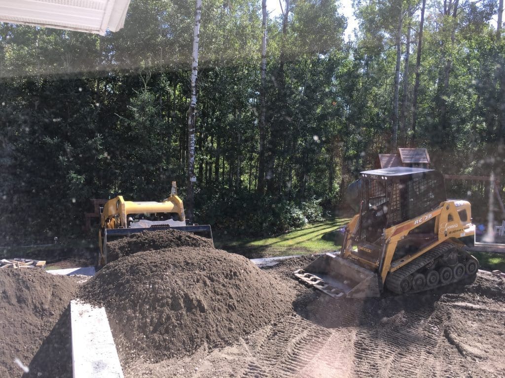 bobcats pushing gravel into house foundation