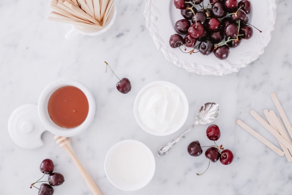 fresh cherries and bowls of honey and yogurt