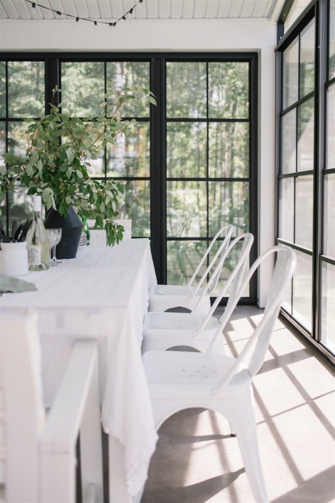 Dining table with white chairs in a sun room