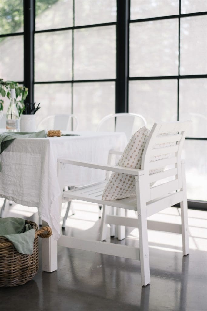 A white wooden chair sitting in front of a window