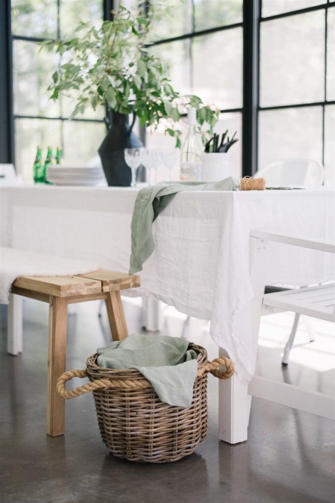 table set with white tablecloth and green linen napkins