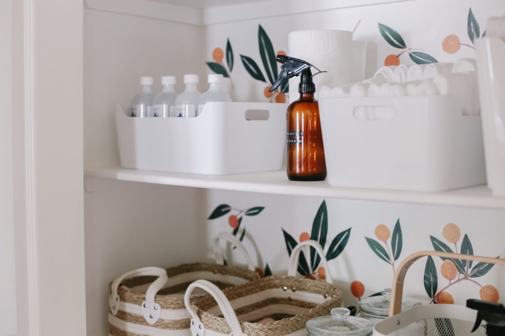amber bottle and white bins in linen closet