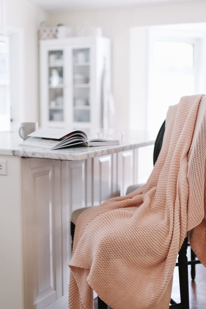 pink blanket draped over a barstool 