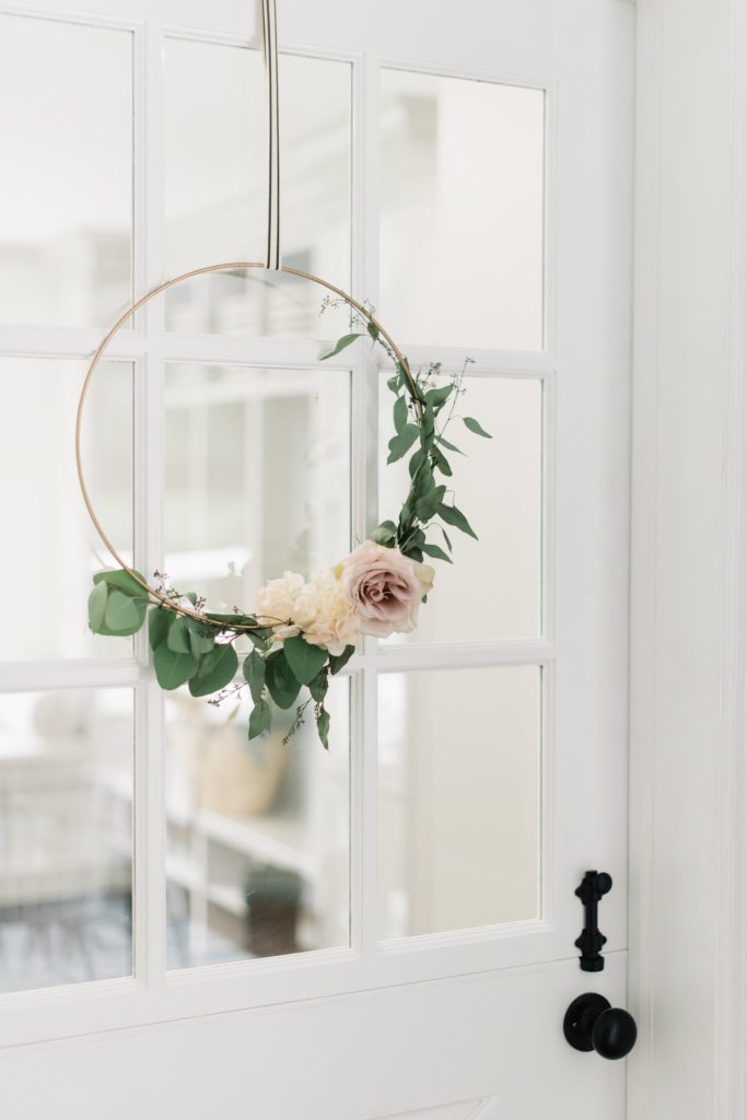 a floral hoop hanging on a glass window