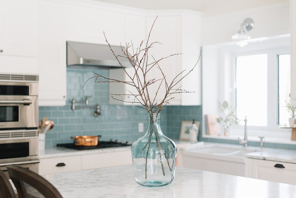 large glass vase with branches in kitchen