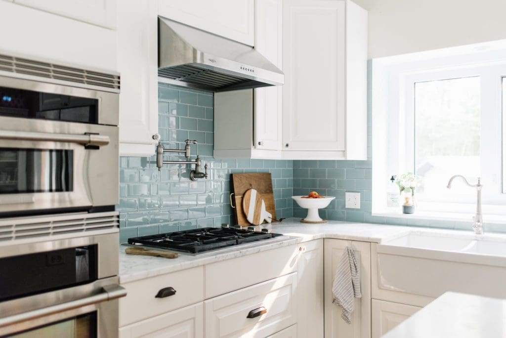 white traditional kitchen decorated for fall with apples on the counter