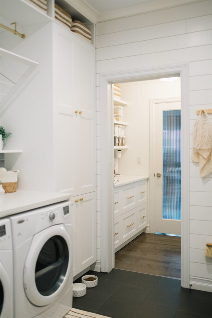 renovated mudroom and pantry space with white cabinets and gold accents