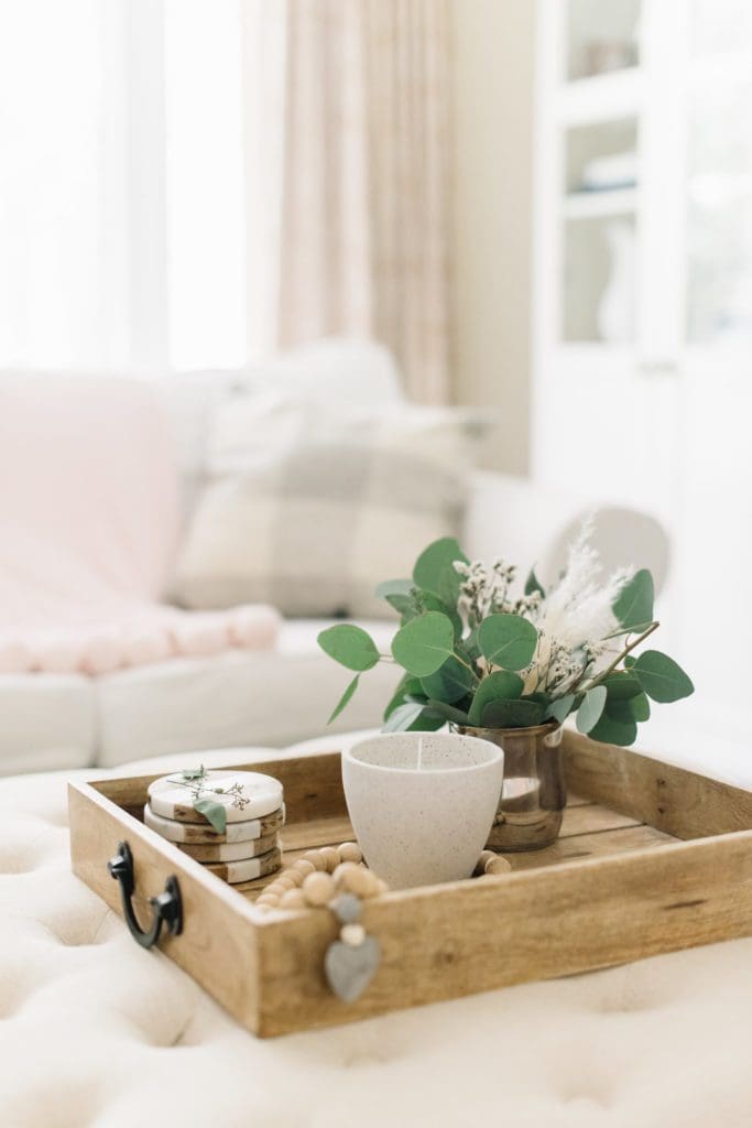 A living room filled with furniture and vase of flowers on wooden tray