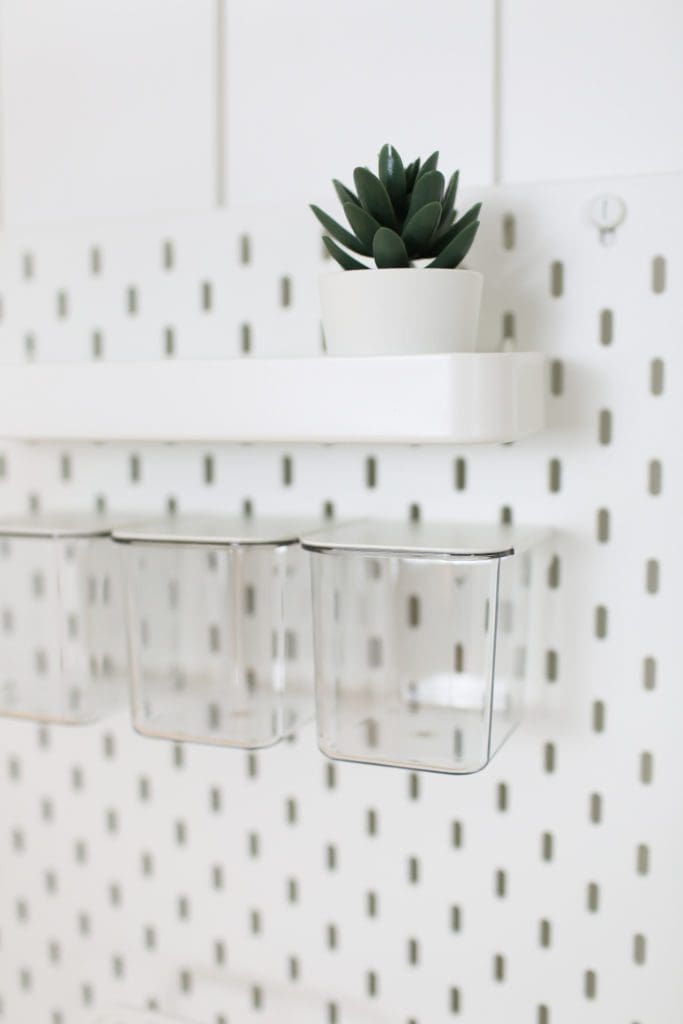 close up of peg board with shelf and glass containers