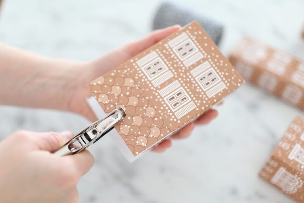 Stapling a hole in the top of a gingerbread gift box house