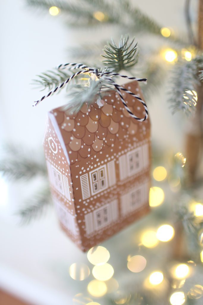 A gingerbread gift box hanging on a christmas tree branch