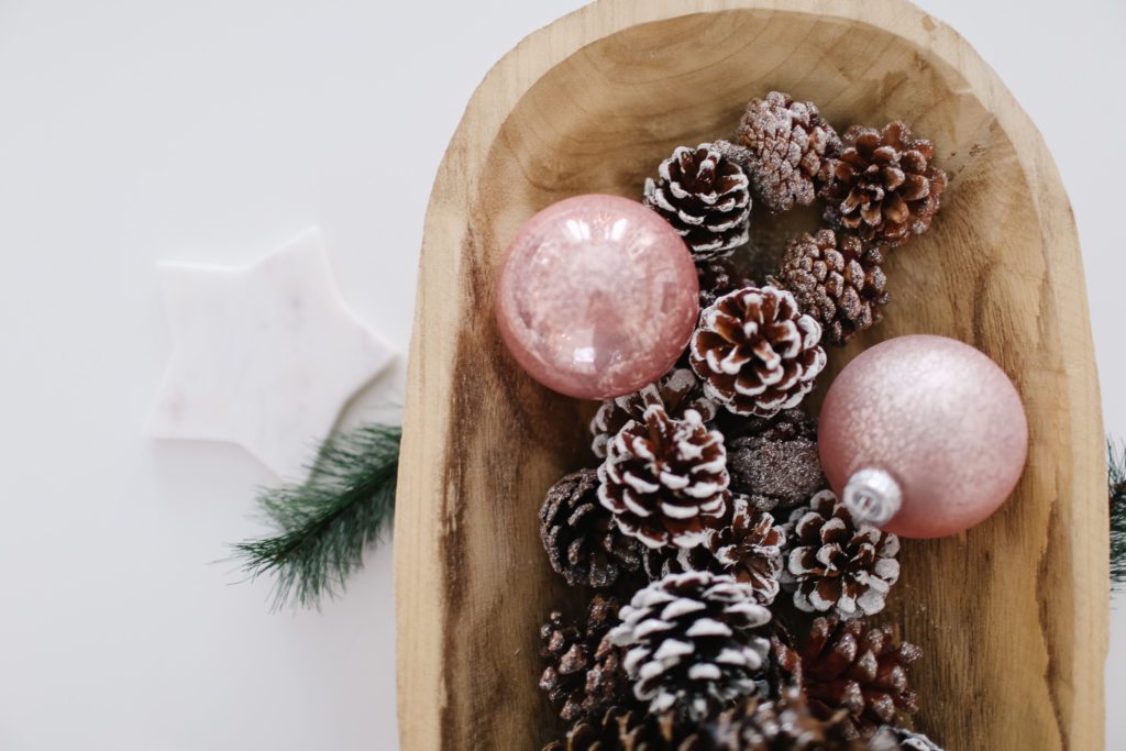 pink ornaments and pinecones in a vintage bread bowl