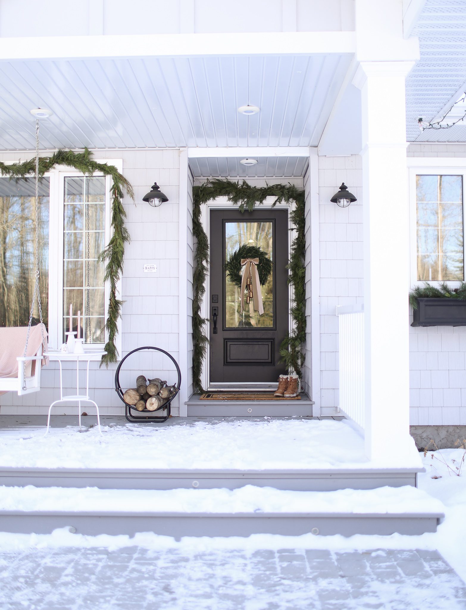 A snowy front porch decorated for Christmas