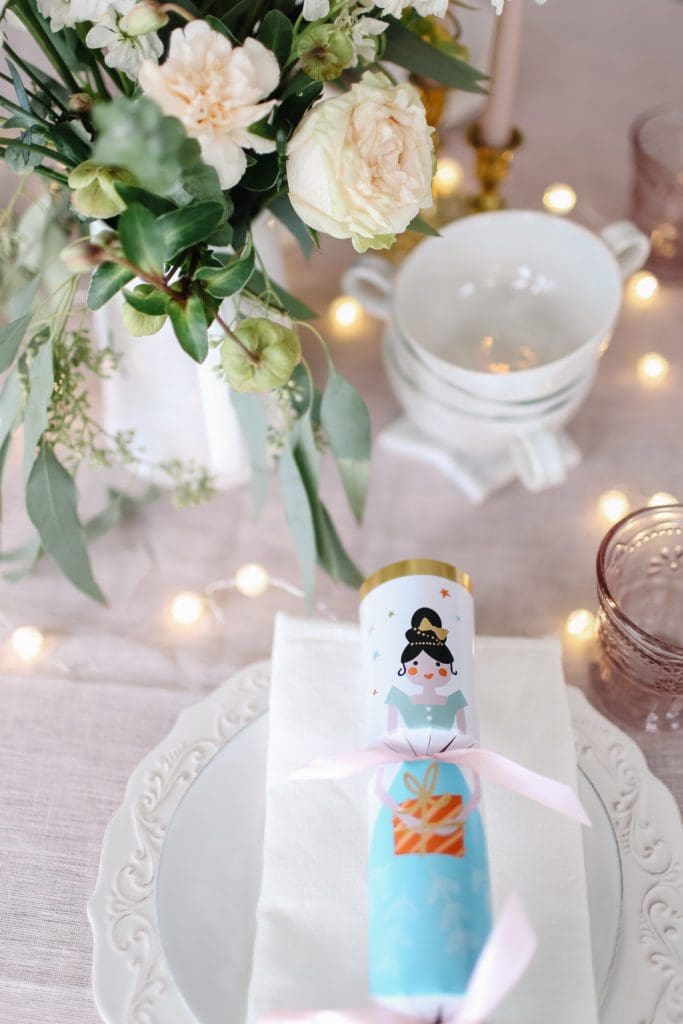 A table with a Christmas cracker and a stack of latte mugs
