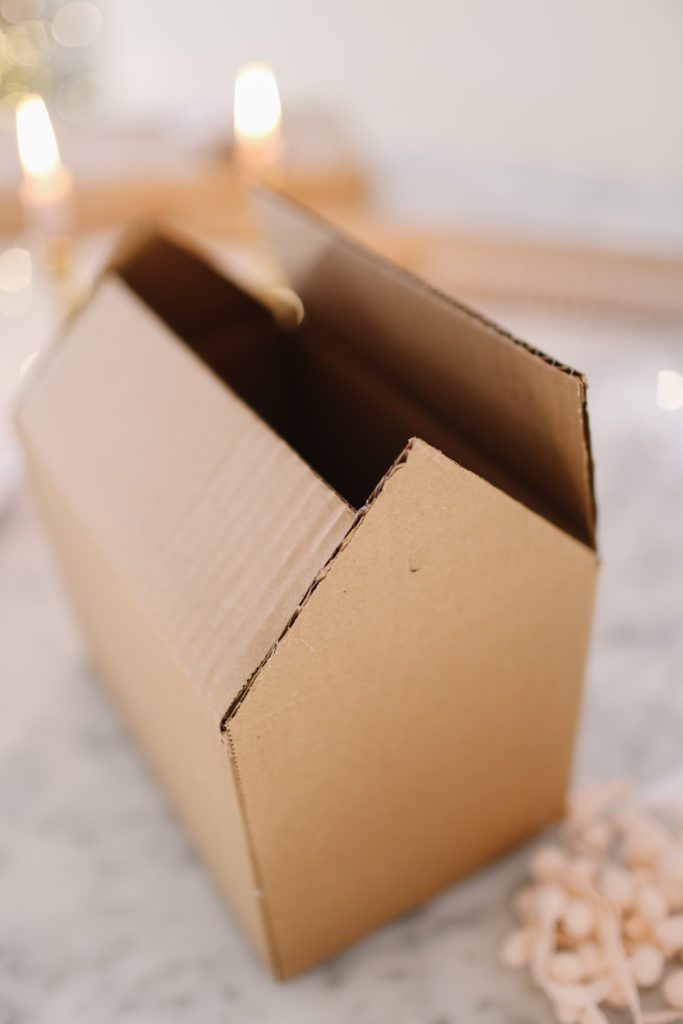 A close up of a box being folded into a house shape
