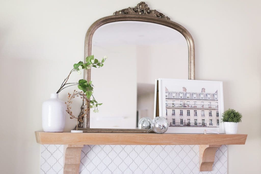 A vase with flowers in front of a mirror