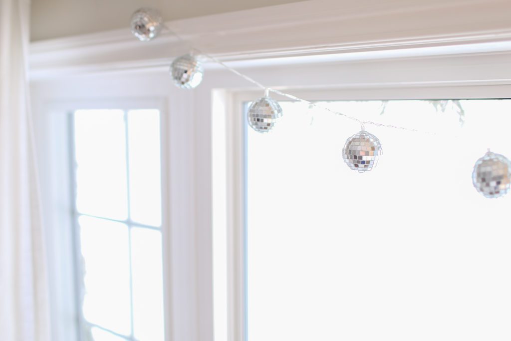 Small disco ball garland hung across a window