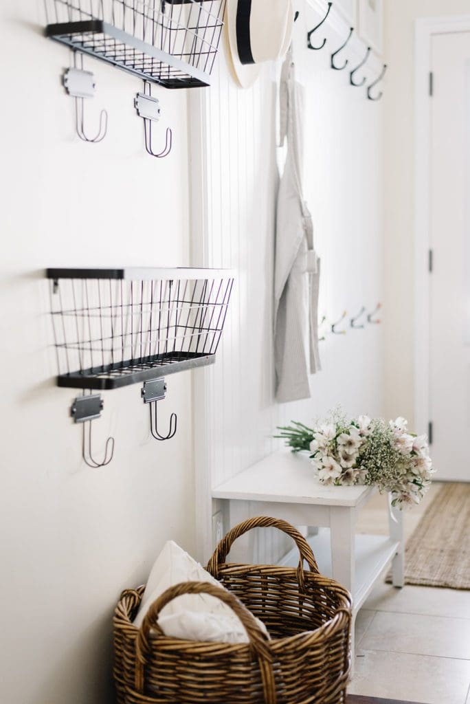 black metal basket with hooks on wall