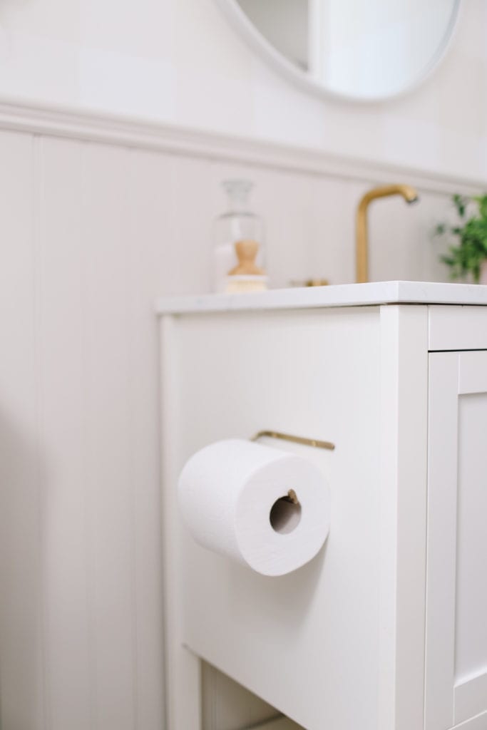 A close up of a brass toilet paper holder