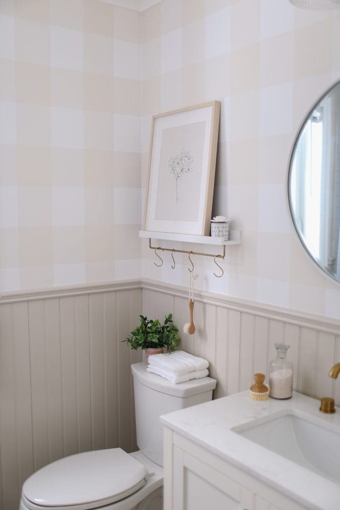 A small bathroom with a shelf above the toilet