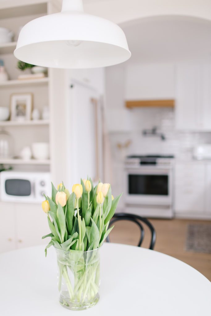 A vase of yellow tulips on a table