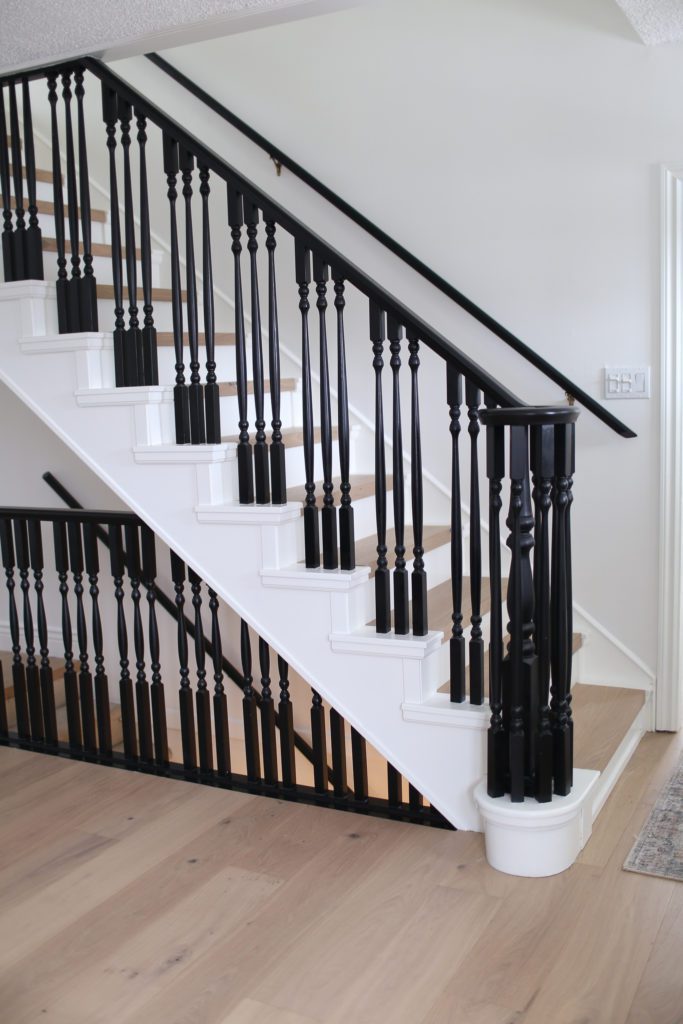 Black railings on white and wood stairs