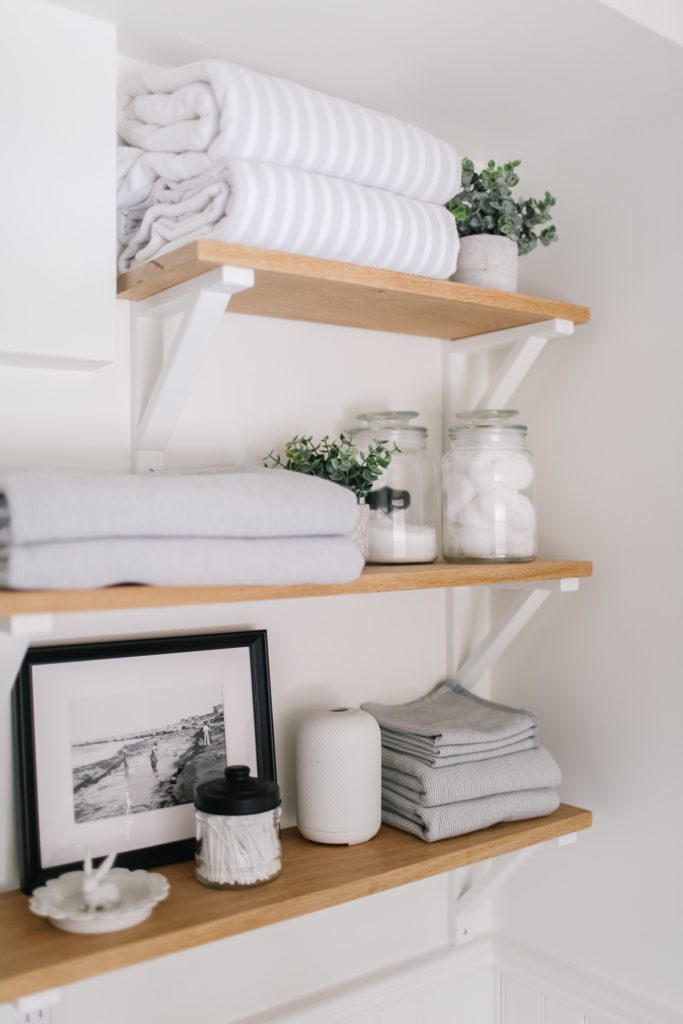 Bathroom shelves stacked with towlels and accessories