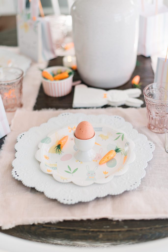 A close up of an egg in an egg cup on an easter themed plate