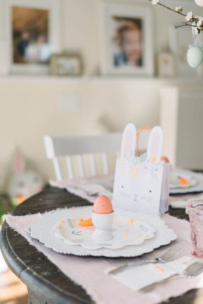 a Bunny gift bag sits behind an easter place setting on a kids easter tablescape
