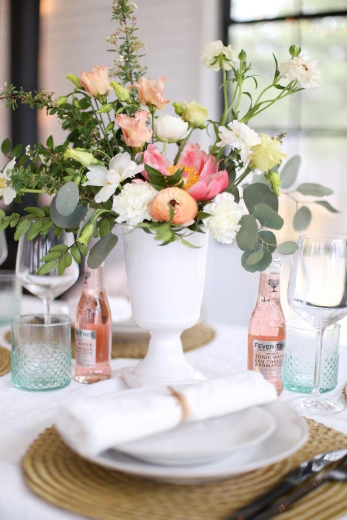 An undone floral arrangement with white, pink and peach flowers plus greens