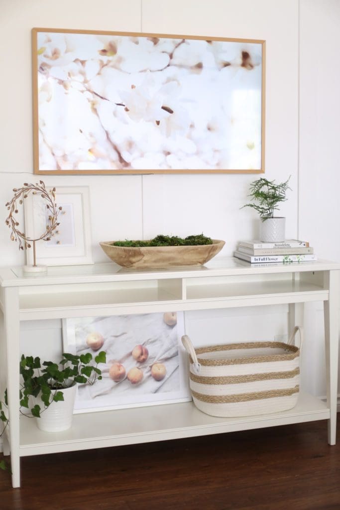 A console table with baskets, book and plants