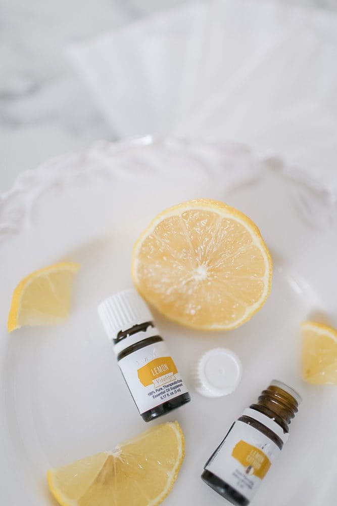 Young Living Lemon Vitality essential oil bottles with slices of lemon